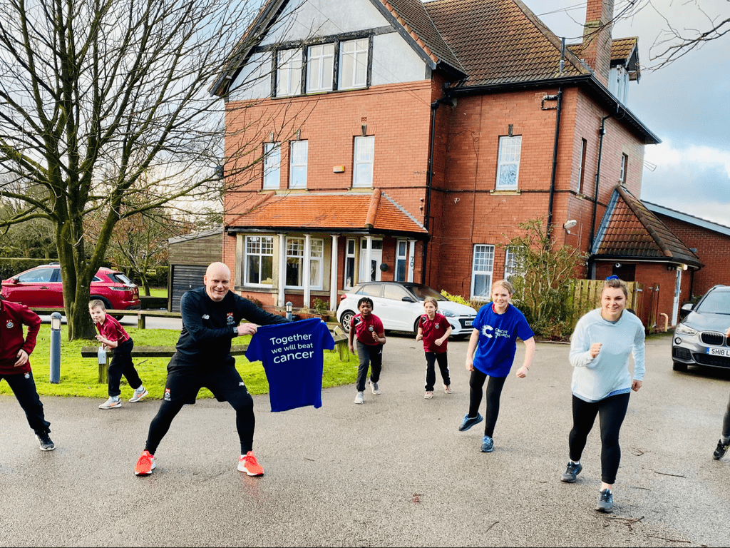 Ashville College Director of Sport, Dominic Bradburne, warms up with some Greenholme boarders