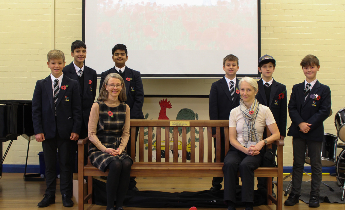 Kenneth's daughters seated on his bench with the boys who wrote the ebook about his experiences (left) and some Remembrance Day assembly speakers