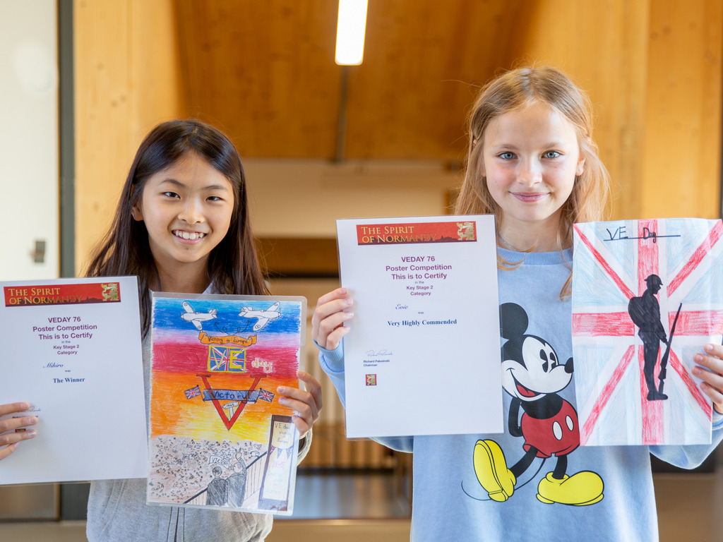 St Benedict's pupils Mihiro and Evie with their winning VE Day posters